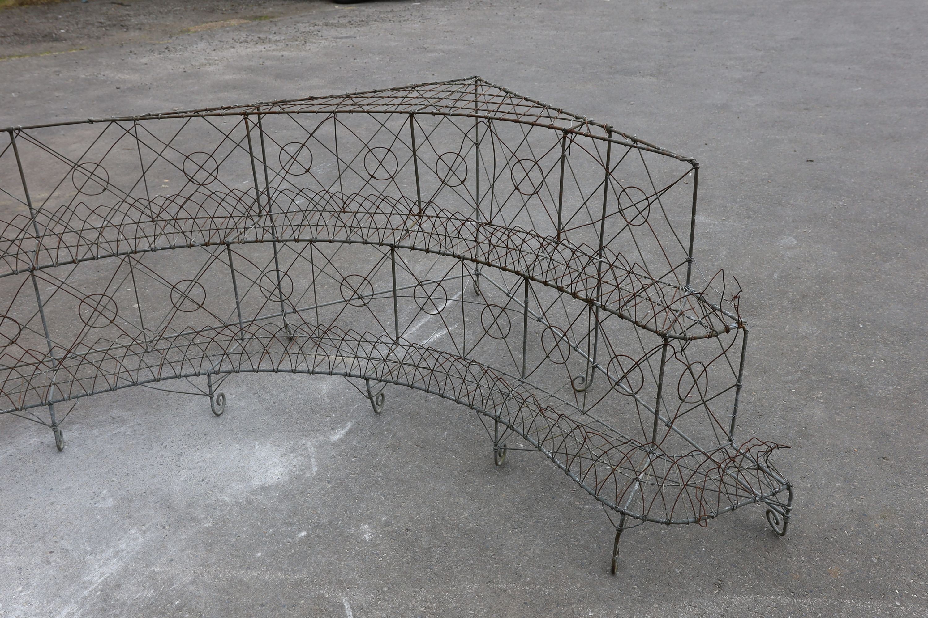 A wirework three tier corner pot stand, width 154cm, depth 180cm, height 68cm